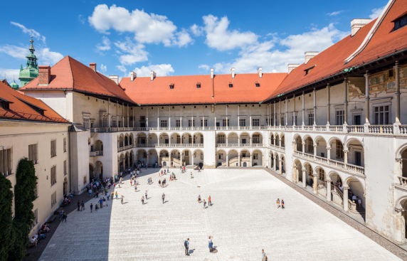 Wielki dziedziniec zamkowy, pokryty kamienną kostką, otoczony z trzech stron budynkami, każde piętro posiada bogato zdobione krużganki, czyli rodzaj balkonu, na budynku z lewej strony winorośl