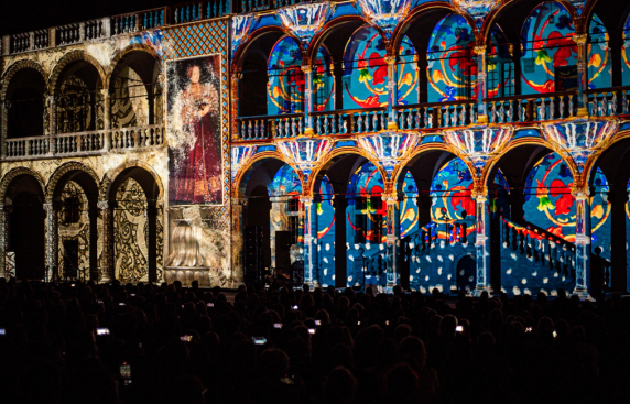 Pokaz świetlny wyświetlany na ścianach budynku, tworzący kolorowe wzory i efekty wizualne.