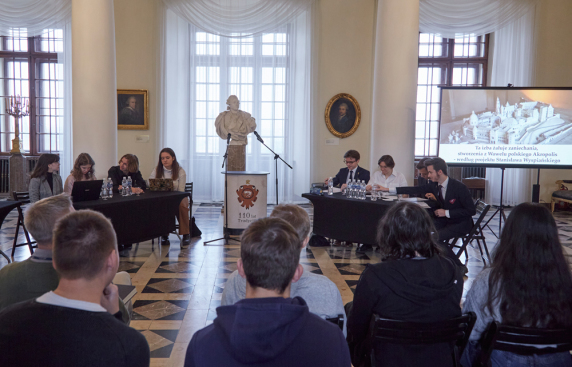 grupa osób na spotkaniu, w jasnej sali muzeum